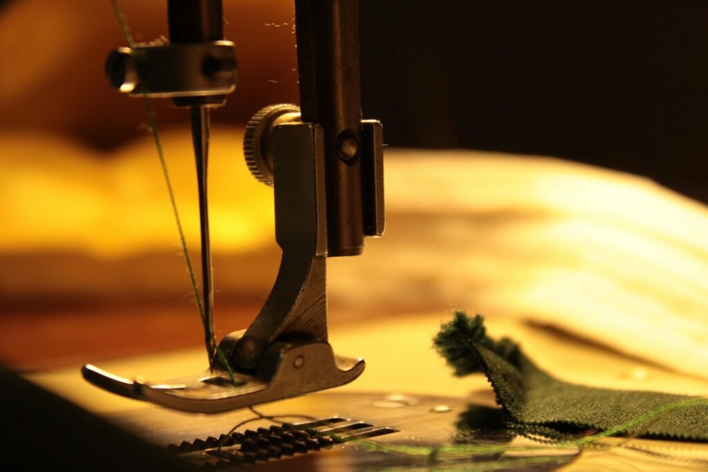 Detailed view of a sewing machine needle stitching fabric, highlighting craftsmanship.